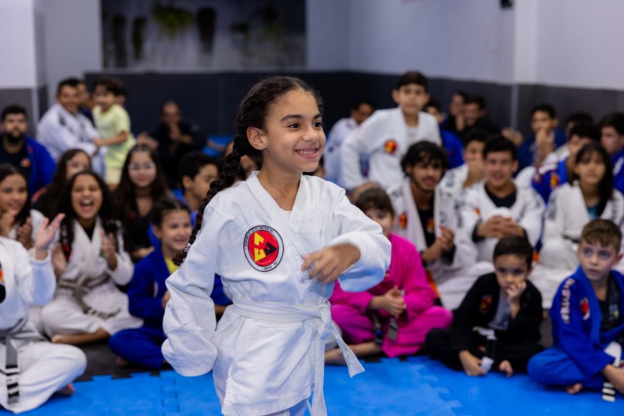 Menina praticando jiu-jitsu com kimono branco — disciplina e transformação